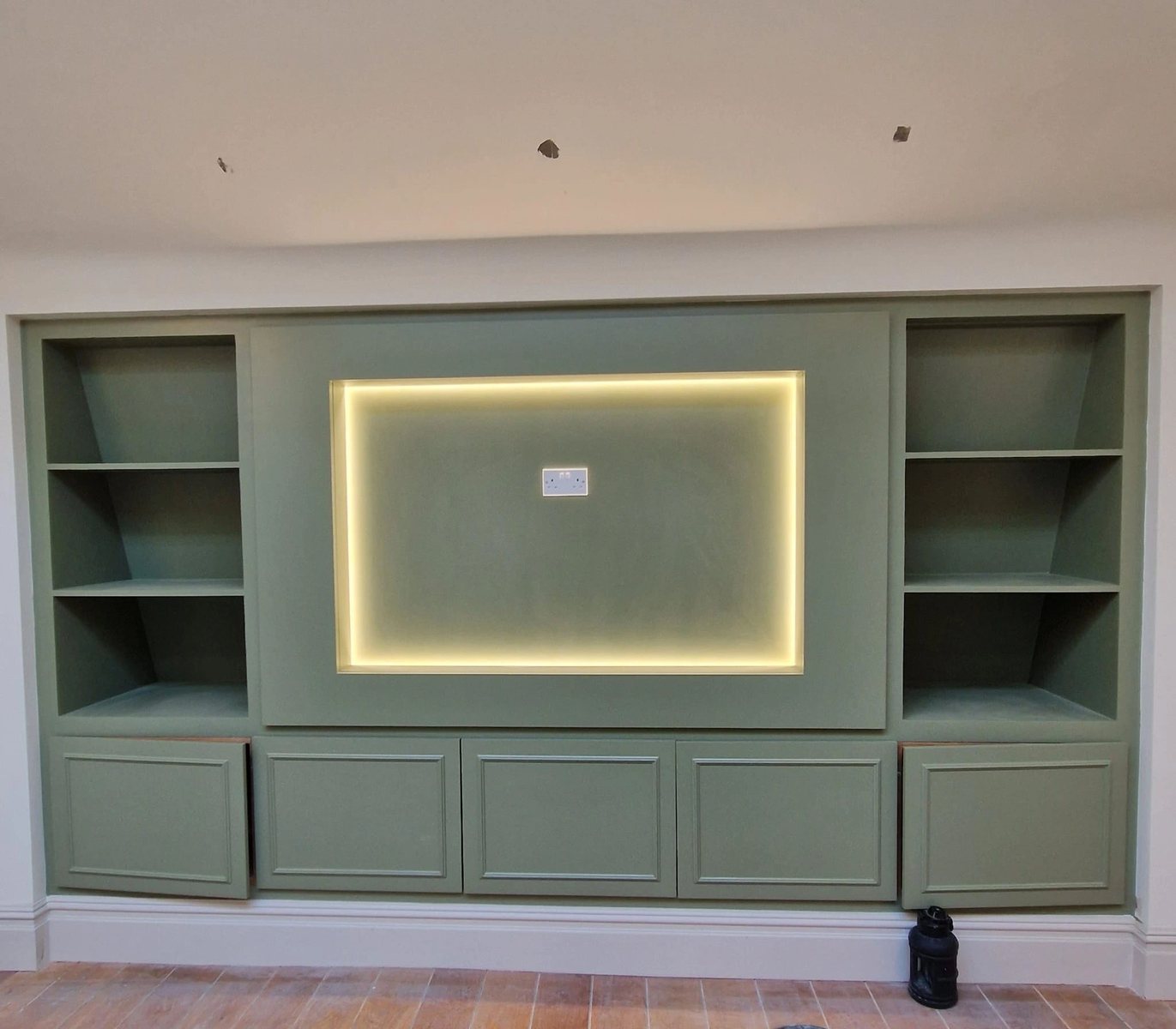 Decorated room with fitted shelving in a soft green finish